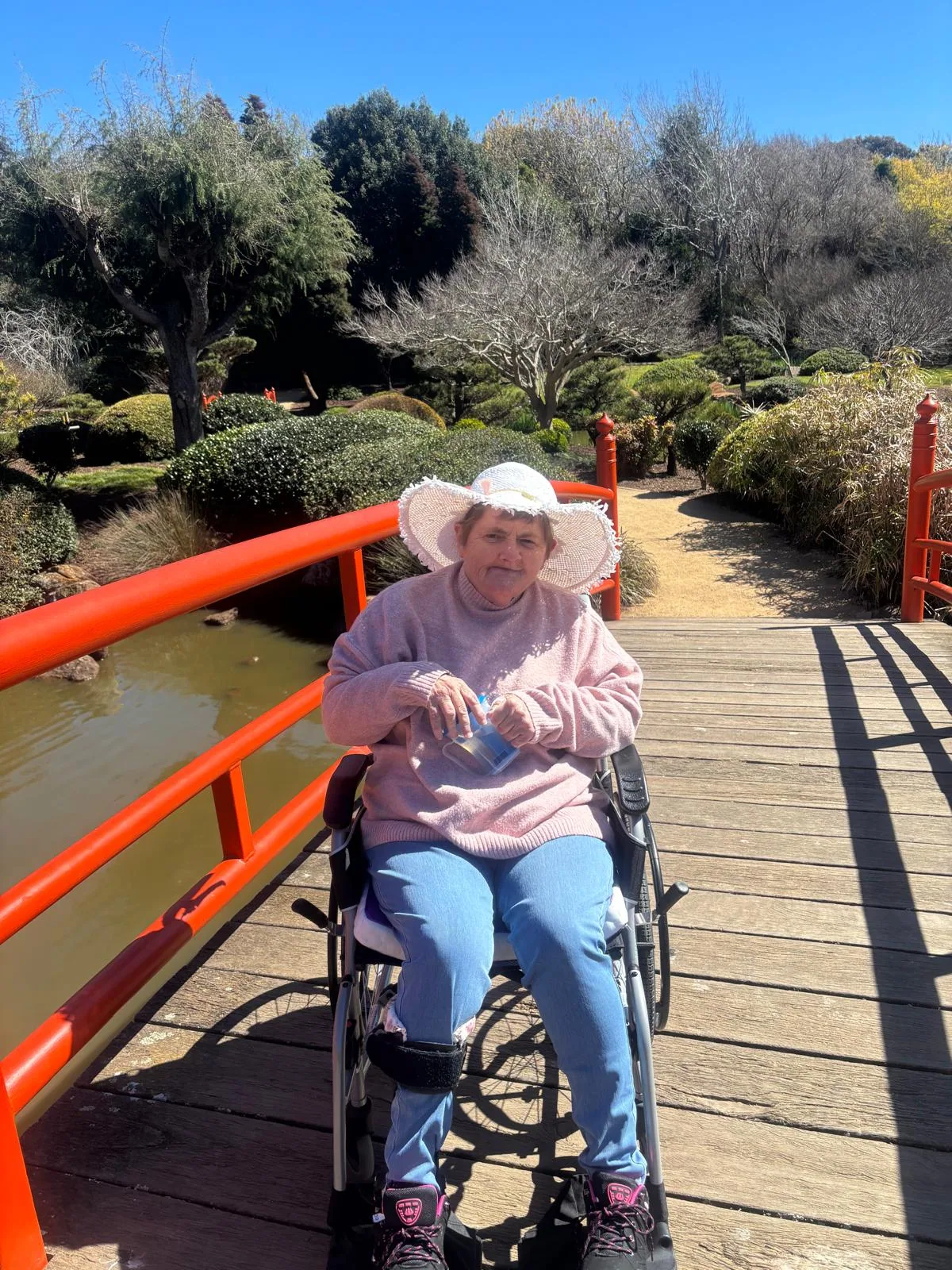 A participant on a red garden bridge on a bright winter day