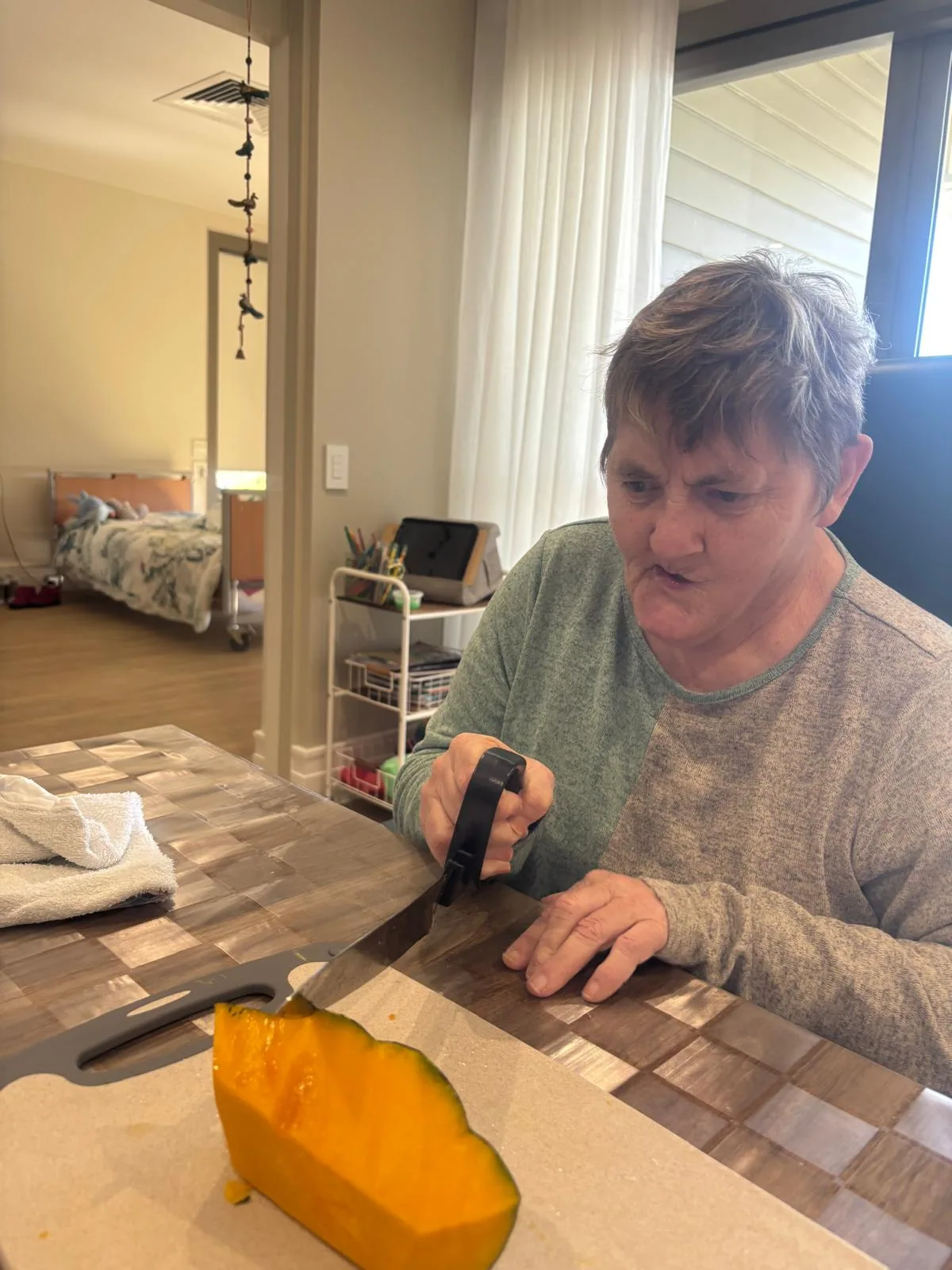 A participant preparing vegetables at the dining table